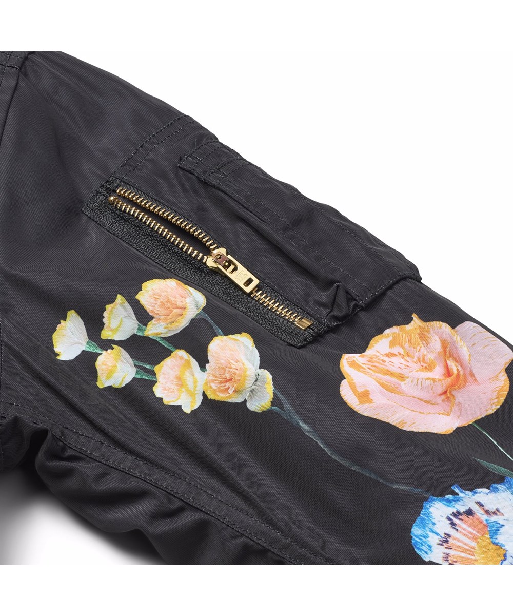 Hedia - Paper Flora - Sort bomberjakke til børn med et farverigt blomsterprint fremstillet i genanvendt polyester.