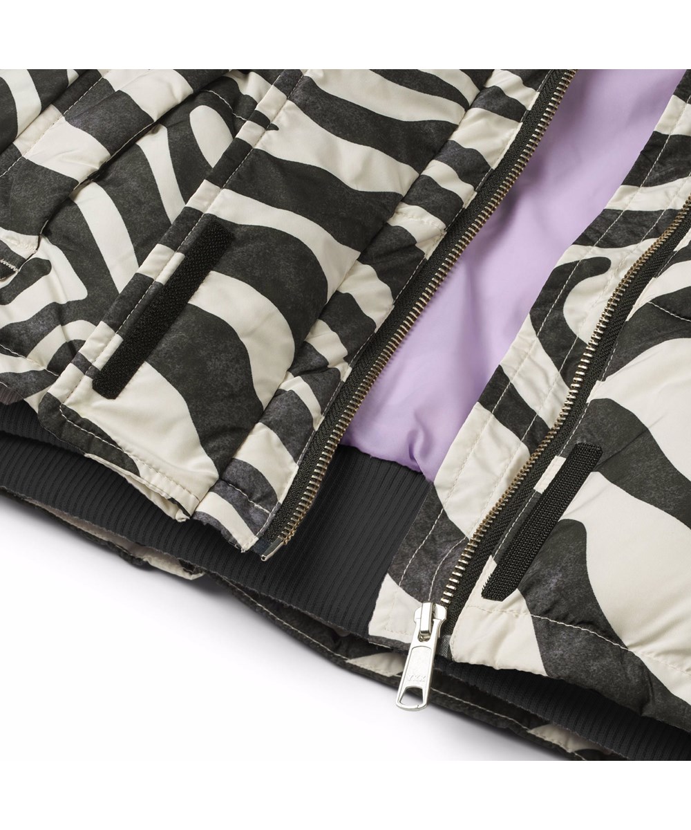 Halfrida - Zebra - Vatteret zebrastribet vest i genanvendt polyester med justerbar elastik i bunden