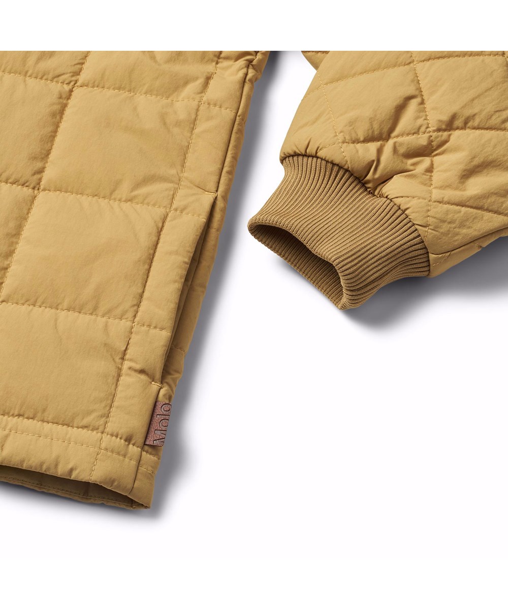 Harold - Suede - Kakifarvet, quiltet, vandafvisende termojakke til børn i genanvendt nylon med canvas detaljer og en lynlås brystlomme.