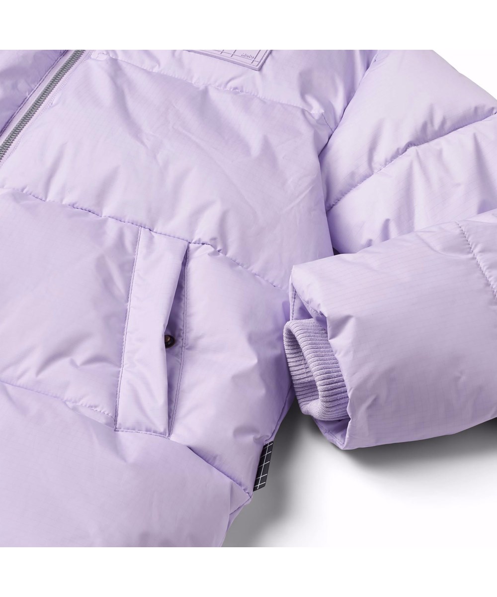 Harper - Pastel Lilac - Varm, pastel lilla dynejakke skabt til den kolde vinter, fremstillet af genanvendt polyester. Jakken har indbyggede vindfang i ærmerne og reflekser for øget synlighed i trafikken