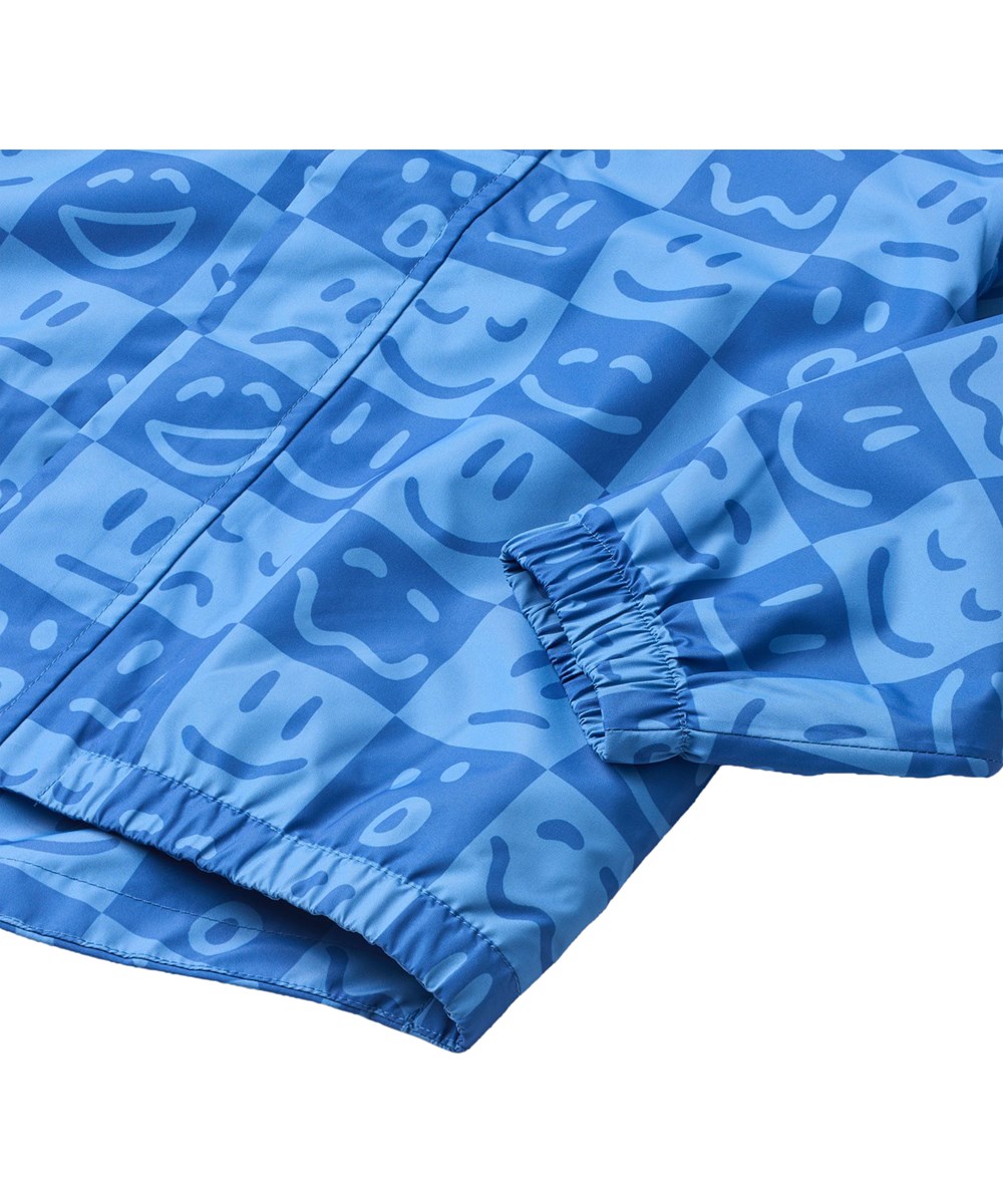 Waiton - Vibe Checks BLU - Vind- og vandtæt regnjakke fremstillet i genanvendt polyester. Jakken er i blå nuancer med et ternet print af forskellige emojis