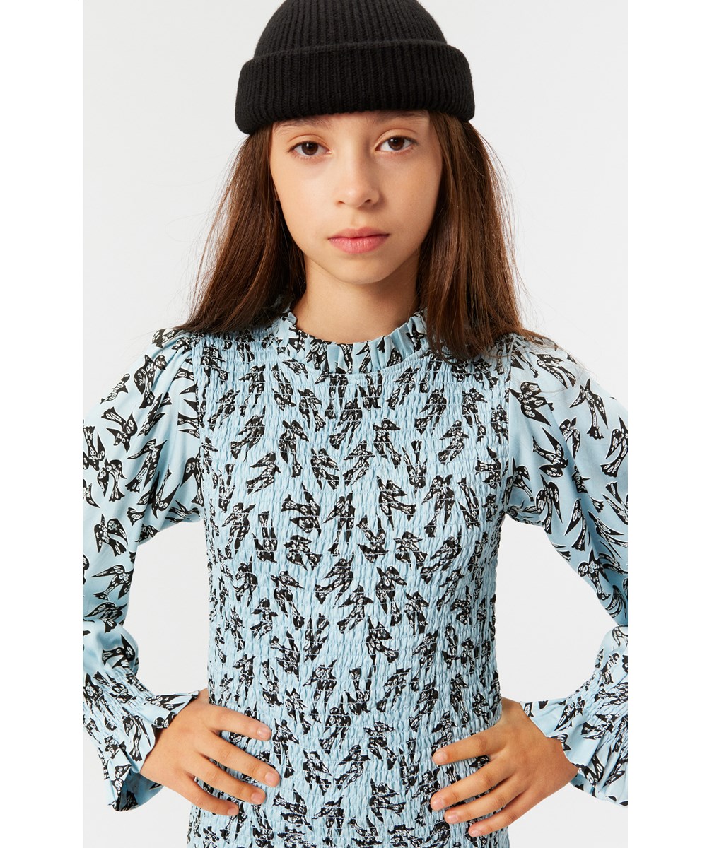 Calesta - Blue Studio Birds - Sofistikeret knælang sort kjole i blødt viscose med smock-effekt samt et print af sorte kunstneriske fugle