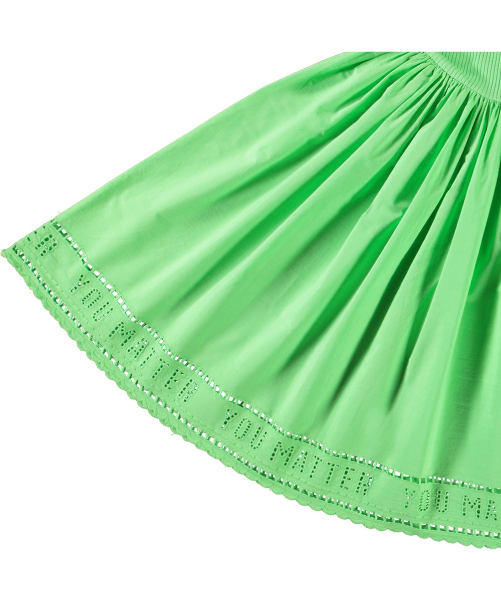 Cibelle - Green Vibes - Langærmet grøn kjole til børn i økologisk bomuld med en tætsiddende ribbet jerseytop, rund hals og et voluminøst rundskåret skørt i bomuldspoplin.