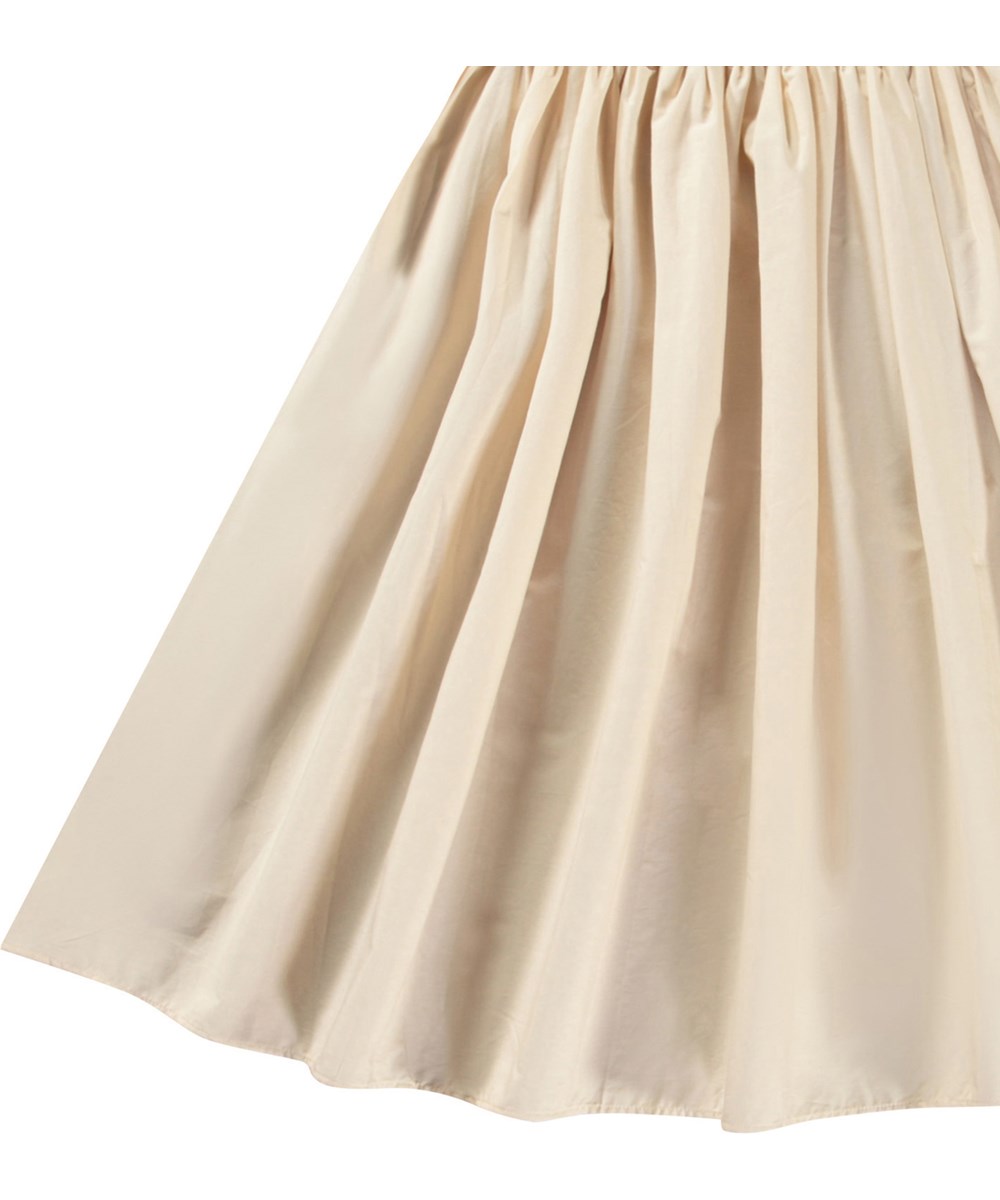 Corella - Brazilian Sand - Beige kjole til børn i økologisk bomuld med et voluminøst poplin skørt.