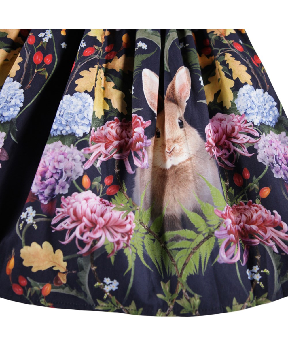 Bonnie - Nouveau Rabbit - Mørkeblå knælang nederdel i økologisk bomuld til børn, med print af blomster og kaniner.