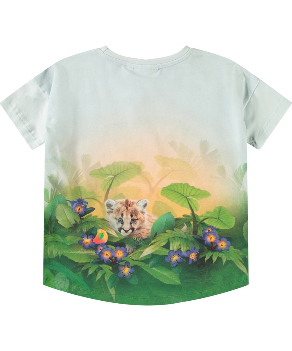 Raeesa - Jungle Games - Lyseblå t-shirt til børn i blødt økologisk bomuld med rund hals, en løs pasform og er længere bagtil end foran.