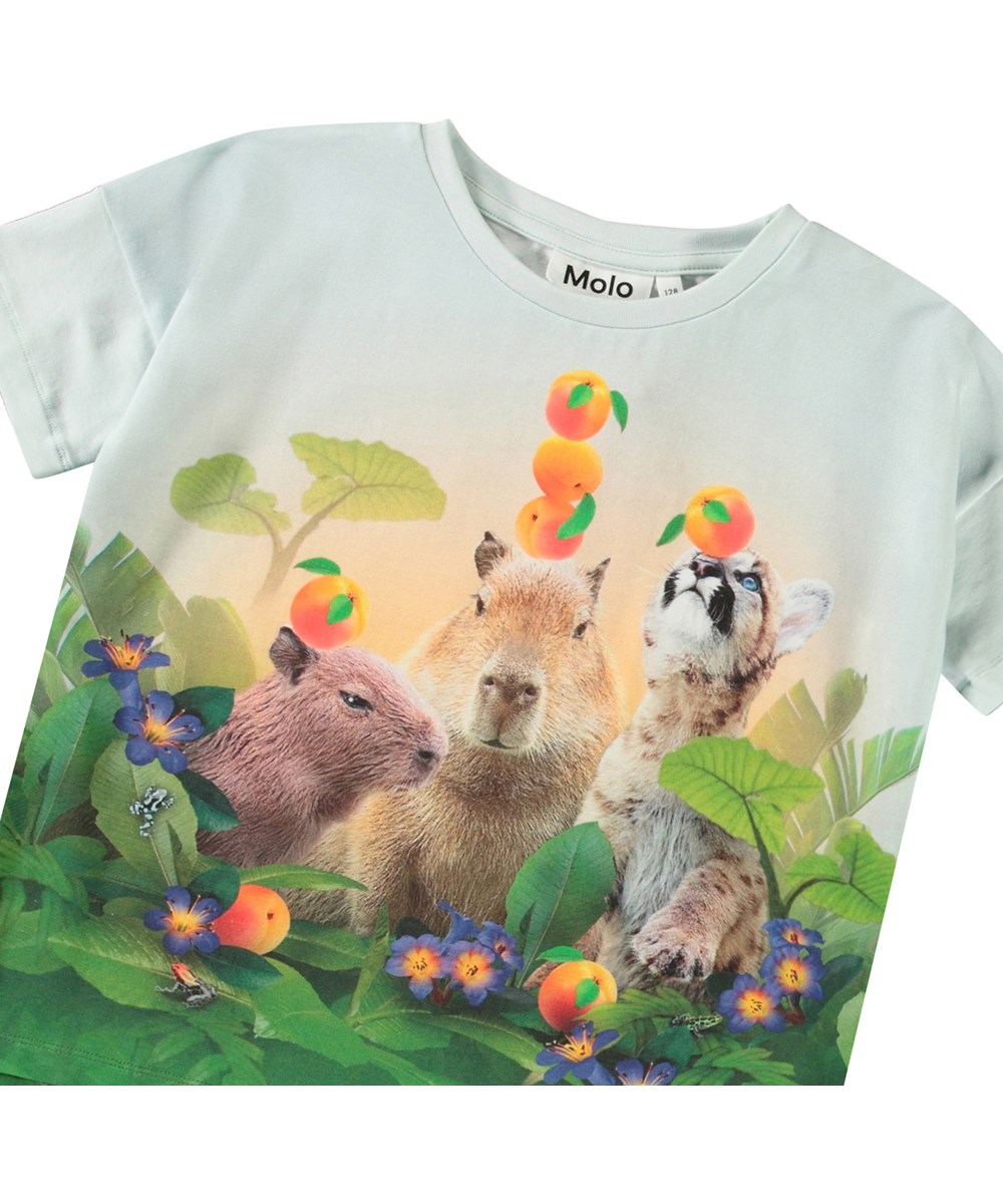 Raeesa - Jungle Games - Lyseblå t-shirt til børn i blødt økologisk bomuld med rund hals, en løs pasform og er længere bagtil end foran.