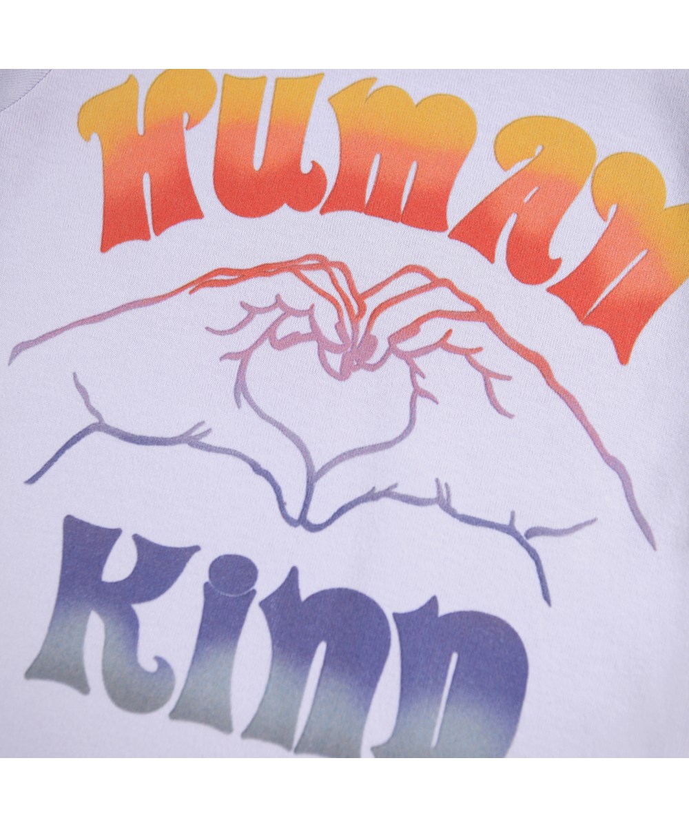 Rhiannon - Thistle - Lilla t-shirt i blødt økologisk bomuld med tekste ´Human Kind´på fronten og hænder der former et hjerte.
