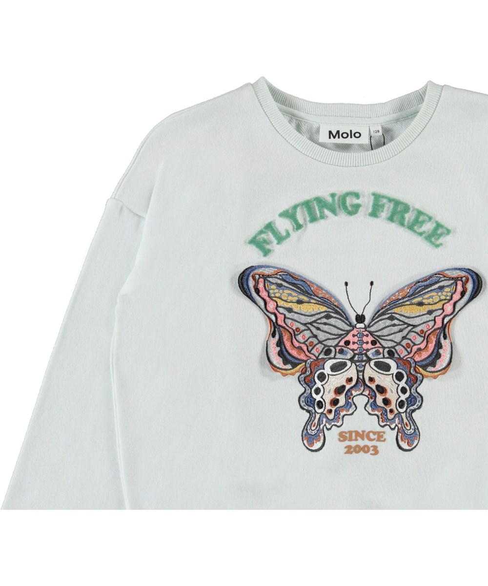 Maja - Flying Free - Lyseblå sweatshirt med broderet sommerfugl