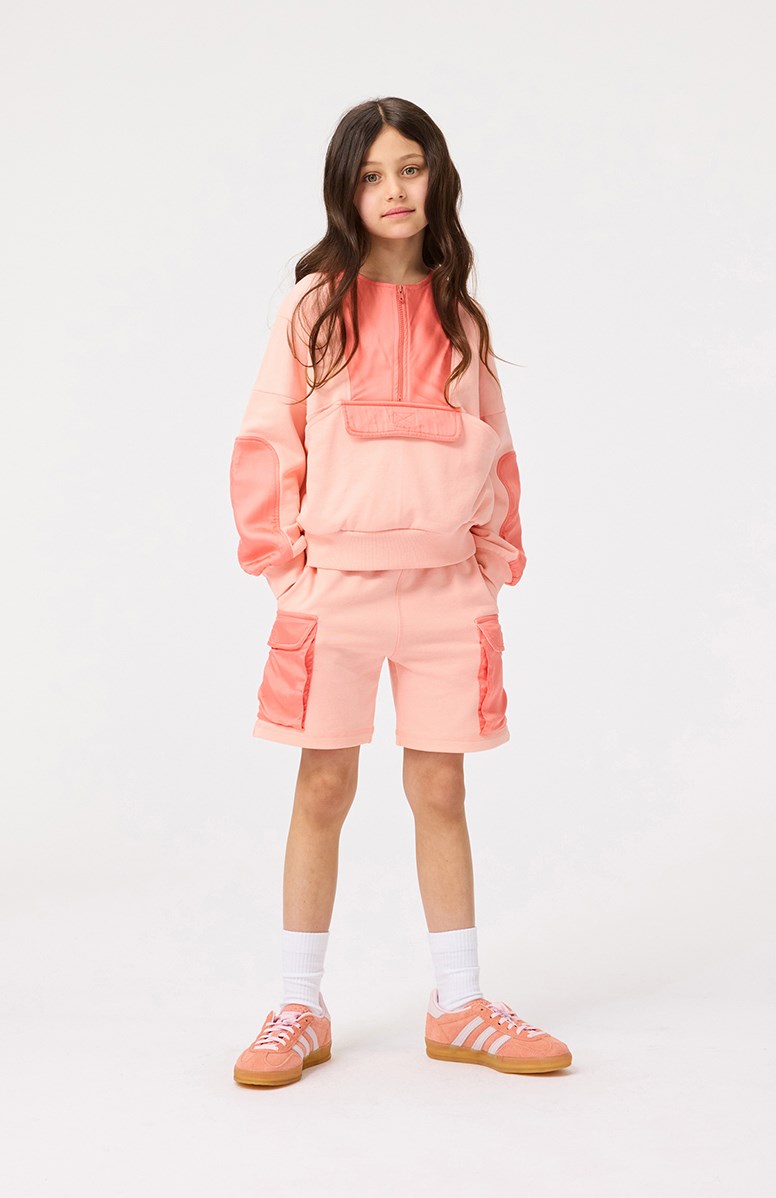 Malissa - Peach - Lys orange sweatshirt til børn i en blød bomuld med ribkanter ved ærmer og i bunden samt lynlås foran på brystet.