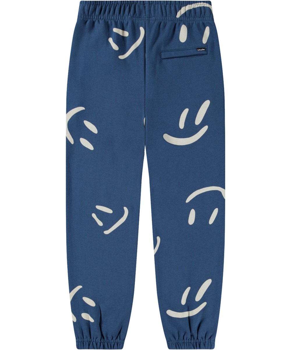 Allen - Big Smiles Blue - Blå byxor i ekologisk bomull med leende ansikten för barn.