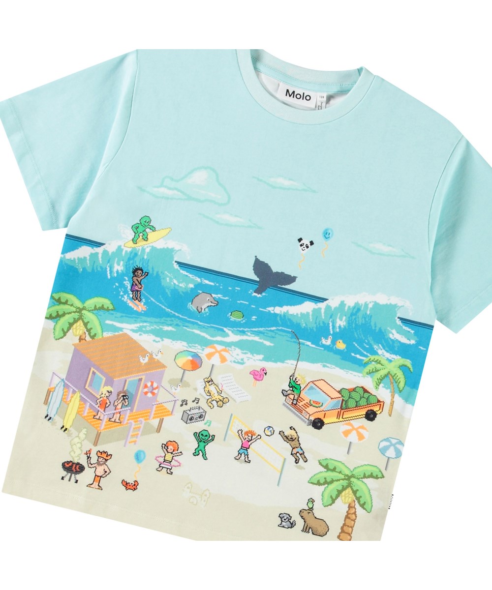 Riley - Pixel Beach - Ljusblå t-shirt med tryck för barn i mjuk ekologisk bomull med korta ärmar och ribbad halsringning.