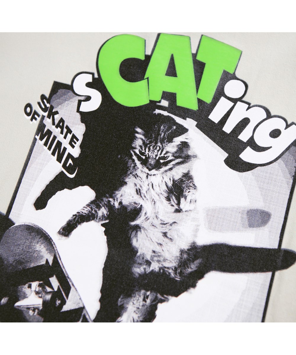 Riley - Scating - Beige T-shirt för barn i mjuk ekologisk bomull med tryck, korta ärmar och en ribbad halsringning.