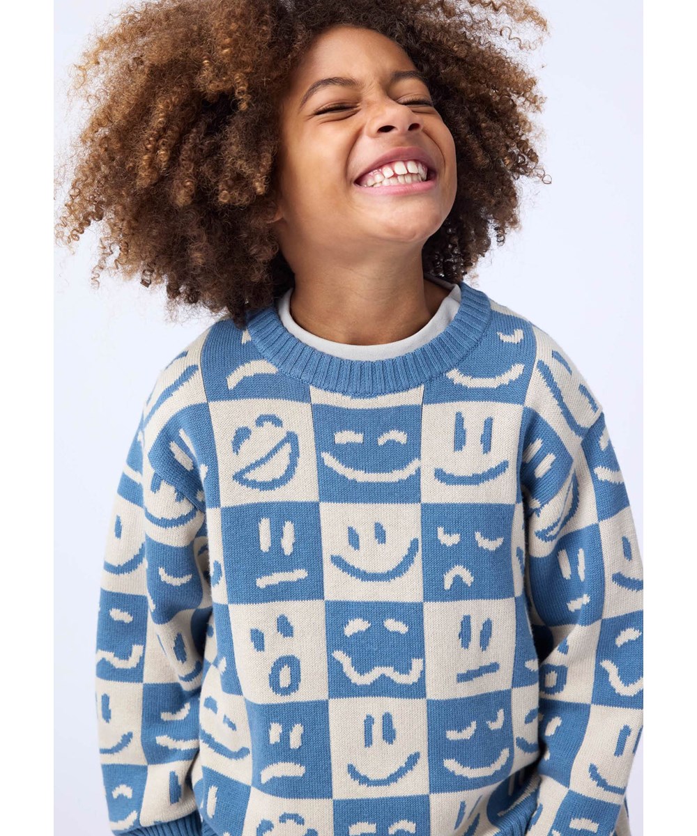 Bello - Moods Knit - Rutig tröja i en blandning av bomull och ull med ett mönster av leende ansikten i blått och vitt.