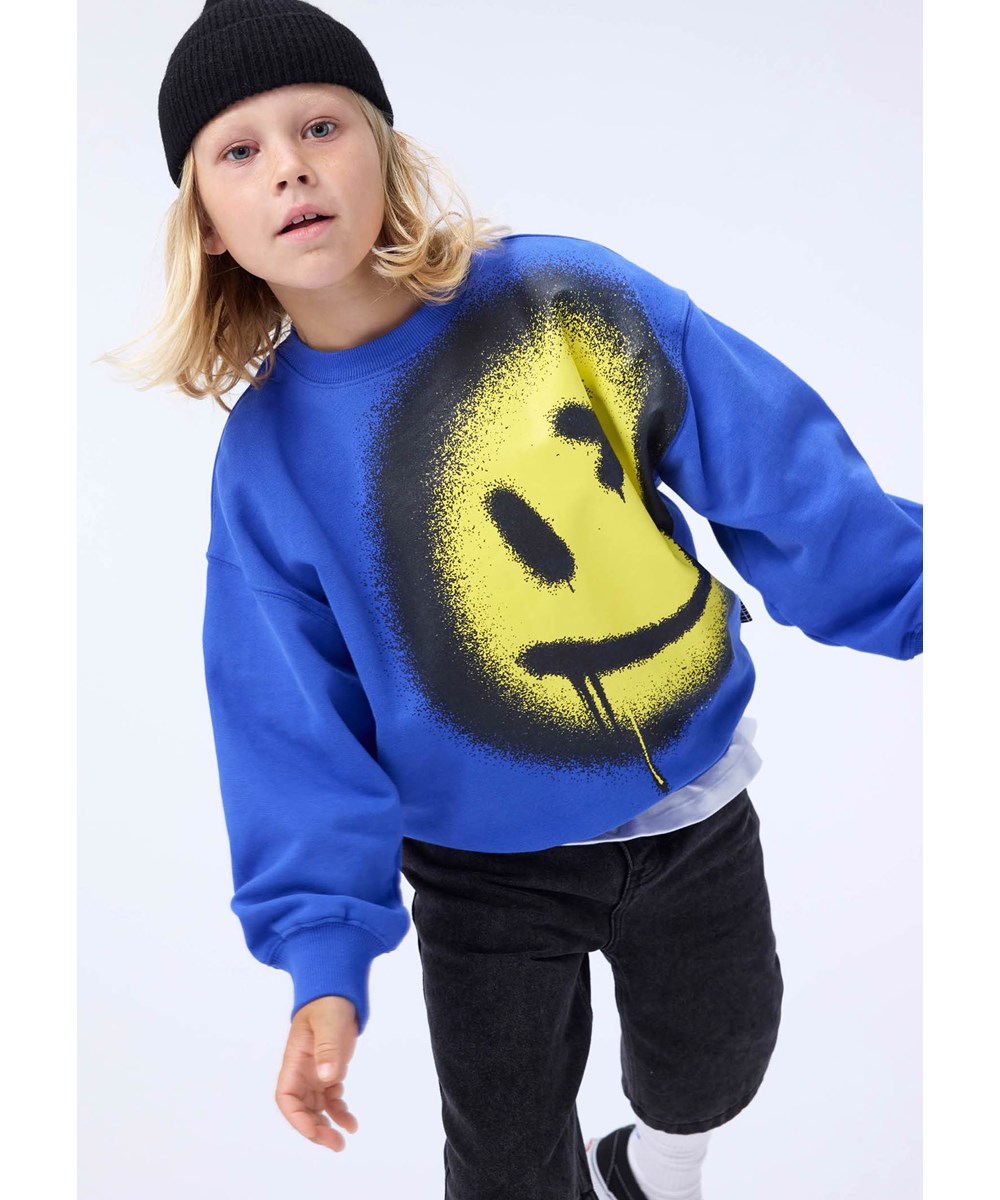 Mar - Drip Smile - Blå tröja för barn i mjuk ekologisk bomull med ett gult leende.