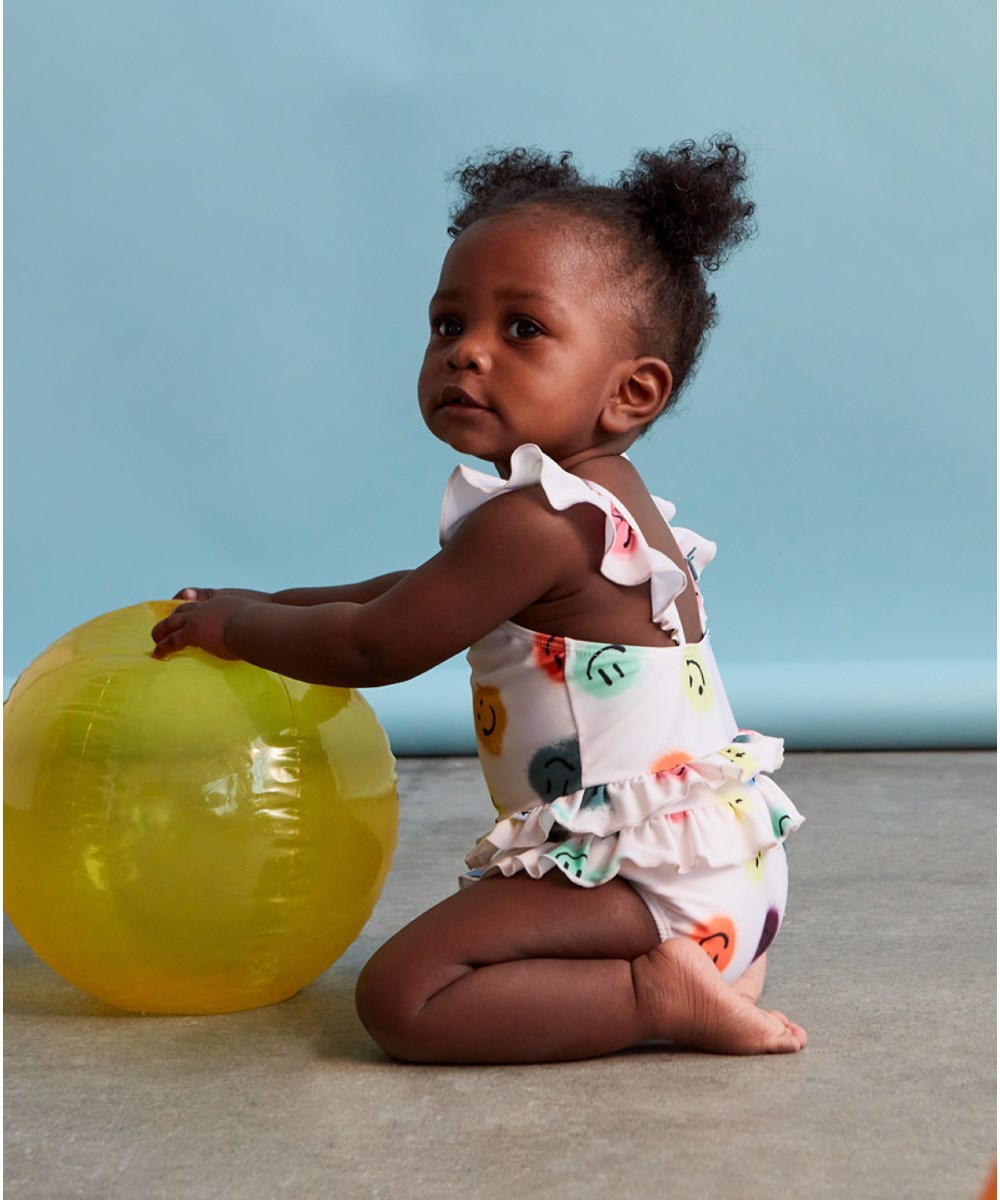 Nalani - Happy Dots - Rose baby swimsuit with ruffles and print of smiley faces