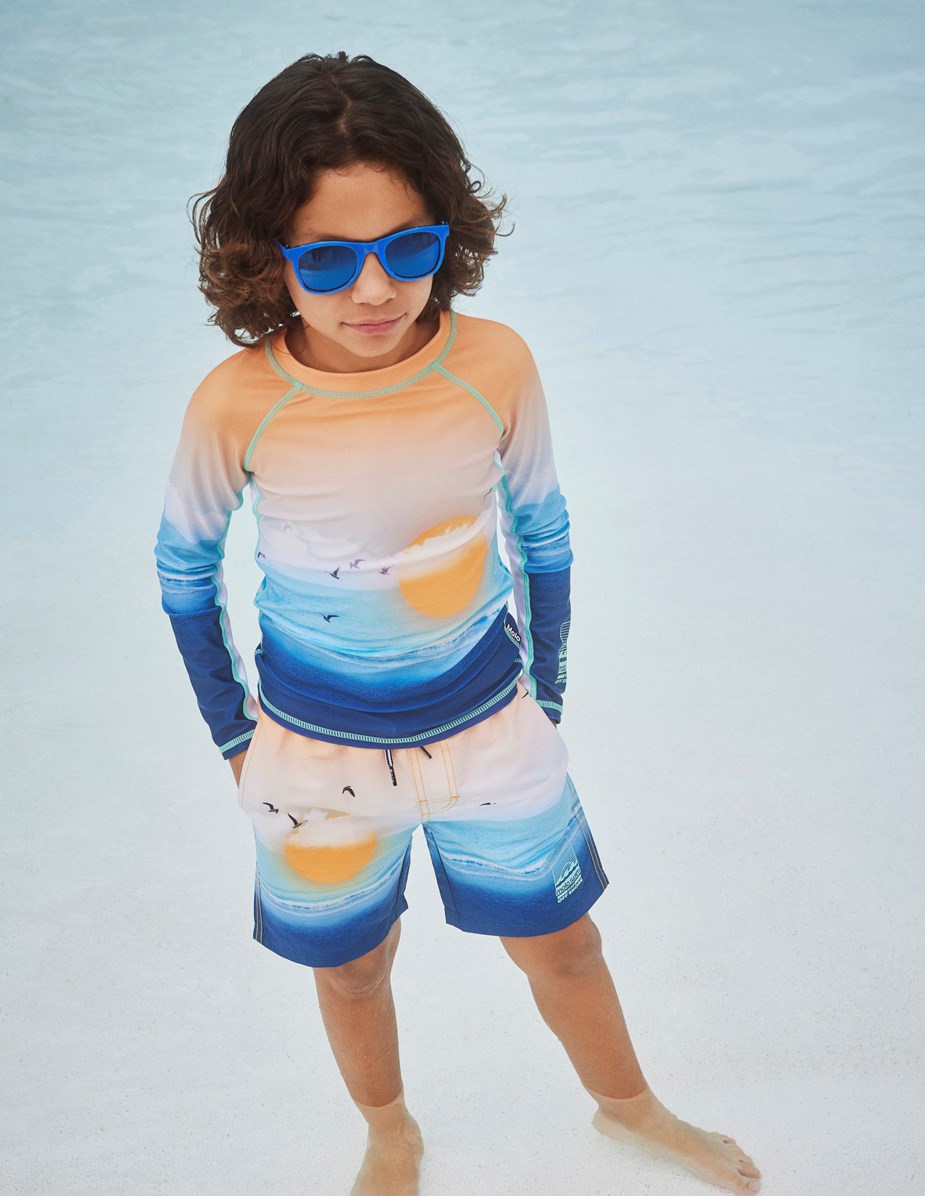 Neal - Sunset Beach - Orange and blue swim shorts with extra length and a placement sun and ocean print 