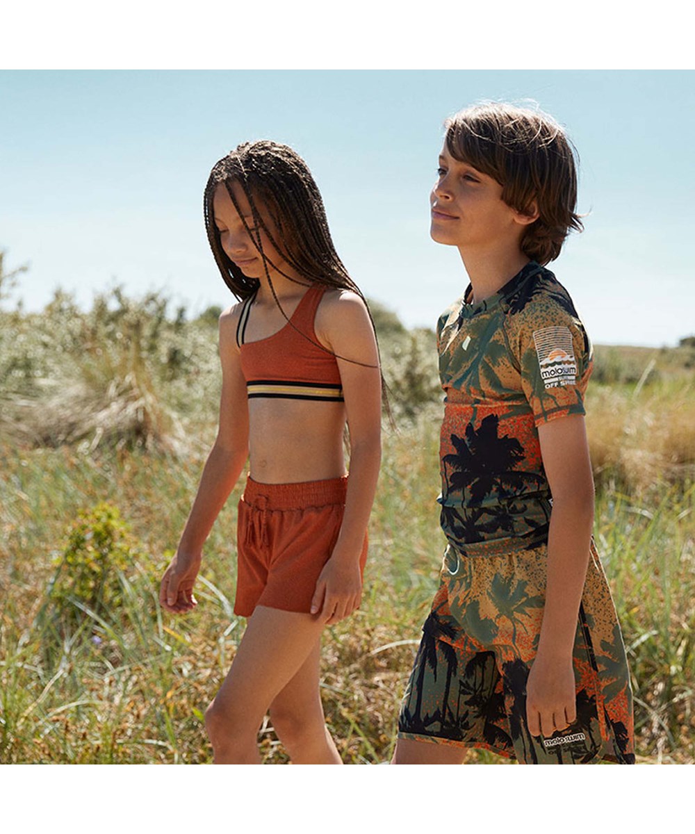 Nicci - Rusty - UV swim trunks in rust red with gold thread 