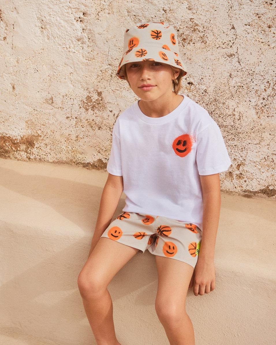 Niko - Fun Play - Sporty, beige swim shorts with basketball print for active children made from recycled polyester with UV protection 50+.