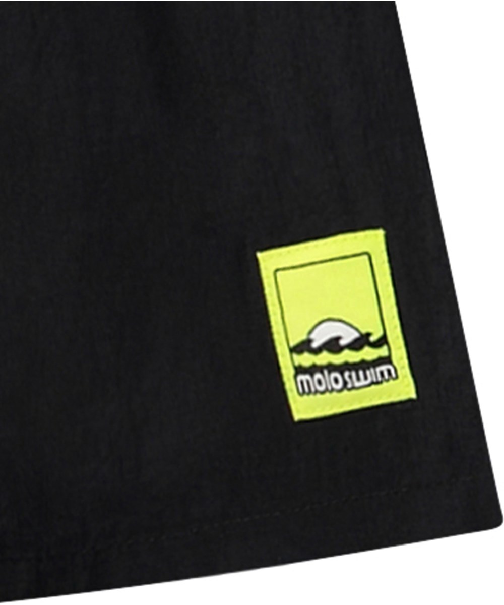 Niko Solid - Black - Sporty black swim shorts for active children in recycled nylon with UV protection 50+.