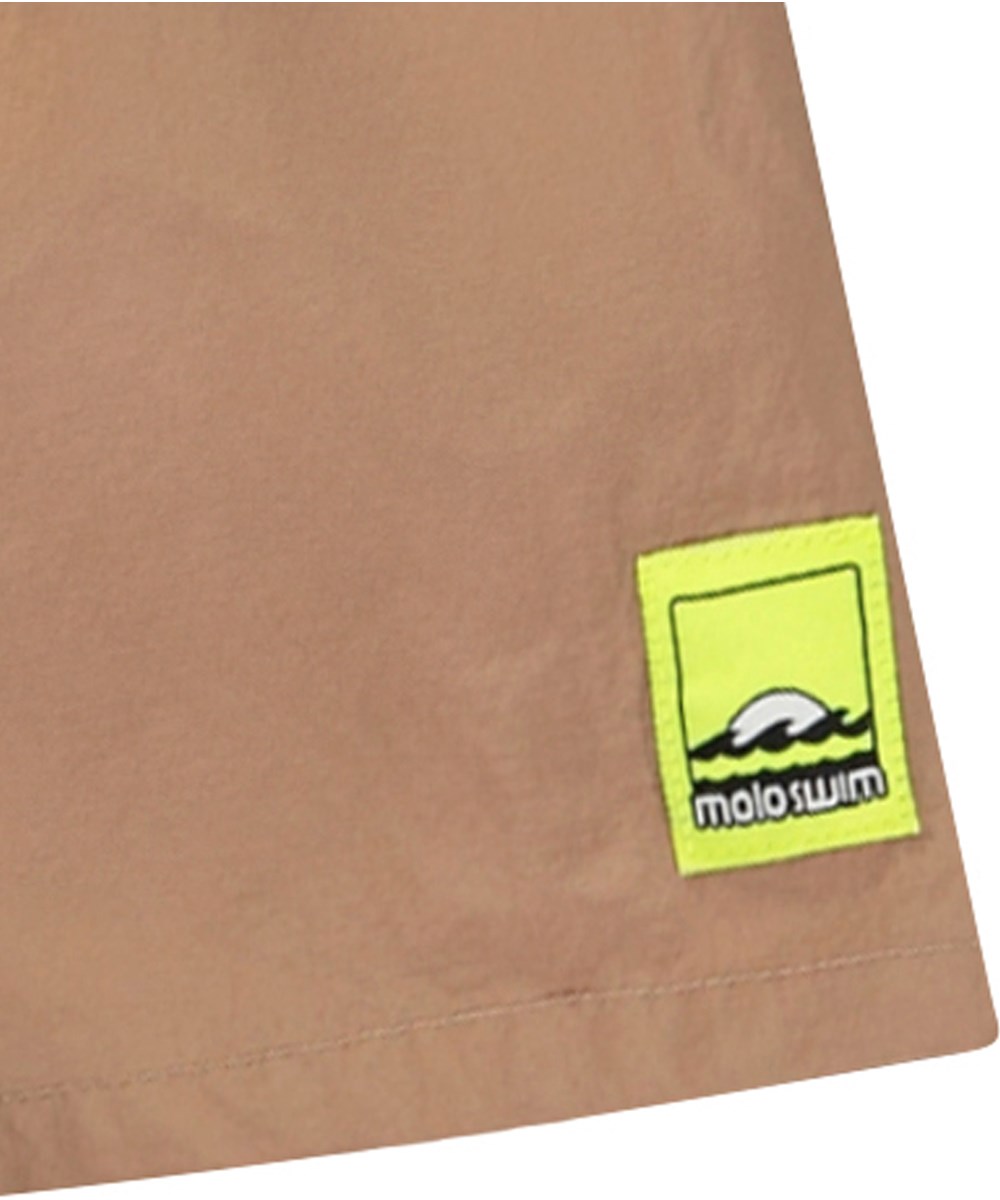 Niko Solid - Sandalwood - Sporty beige swim shorts for active children in recycled nylon with UV protection 50+.