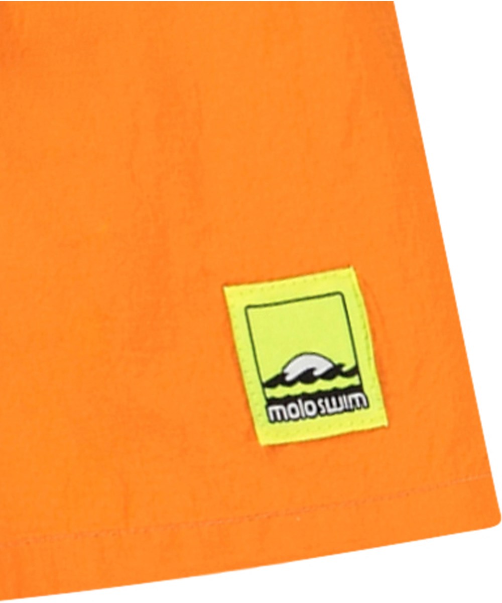 Niko Solid - Tumeric - Sporty orange swim shorts for active children in recycled nylon with UV protection 50+.