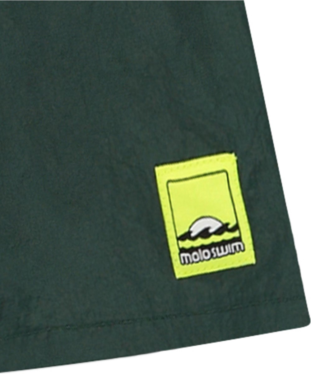 Niko Solid - Wood Green - Sporty dark green swim shorts for active children in recycled nylon with UV protection 50+.