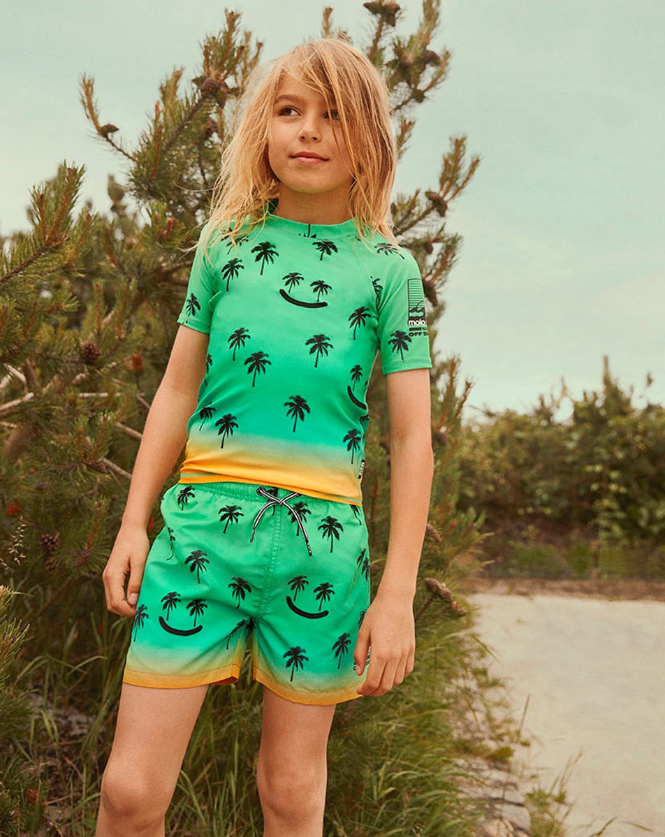 Niko - Summer Happy - Green swim shorts with orange background and palm trees  