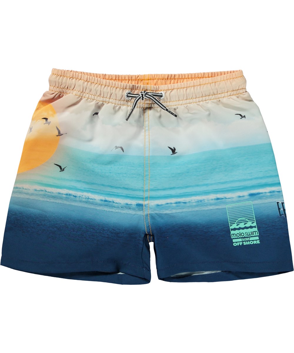Niko - Sunset Beach - Blue and orange swim shorts with short legs and placement beach print 