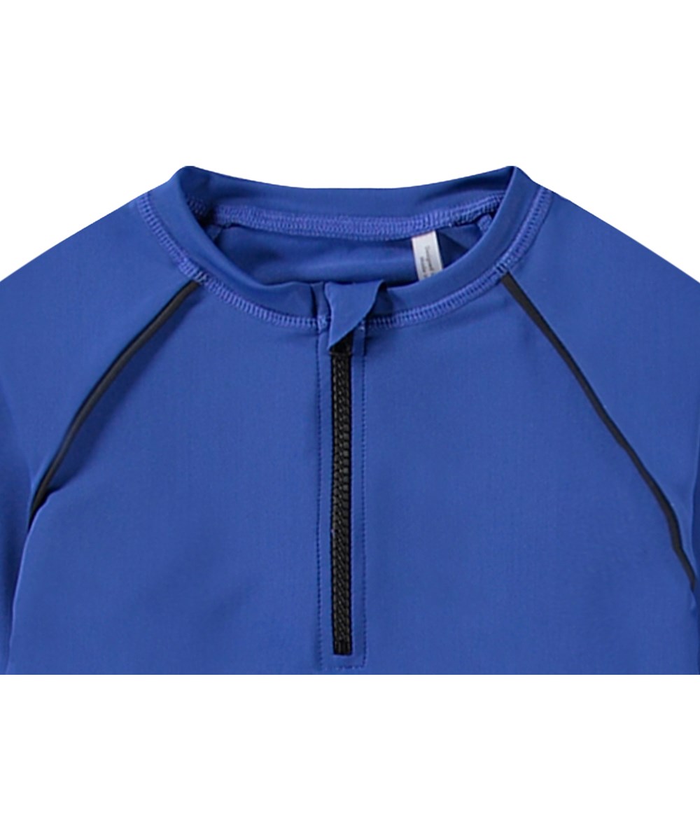 Noble - Reef Blue - Blue rashguard with zip for active children made from recycled polyester with UV protection 50+.