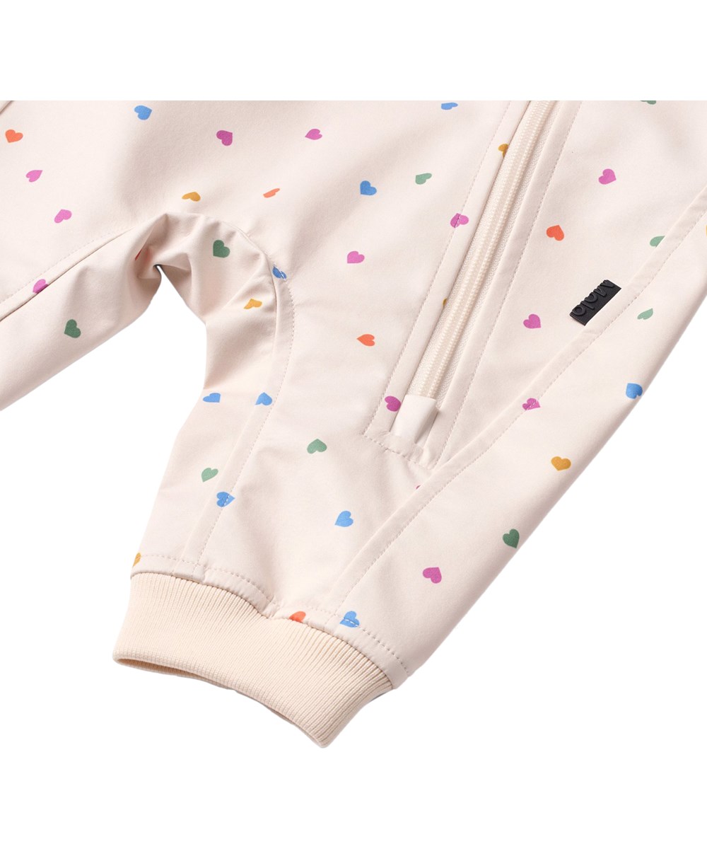 Hill - Confetti_Rainbow - Beige vind- och vattenavvisande softshell-overall för de små med fleecefoder och hjärtmönster.