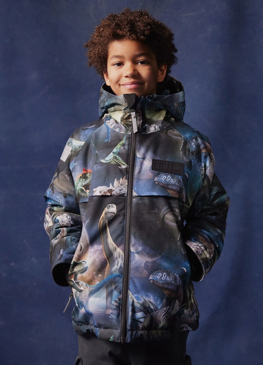 Castor - Dino In Space - Vind- och vattentät vinterjacka för barn i återvunnen polyester med en tryck av dinosaurier i rymden i nyanser av blått, grönt och brunt.