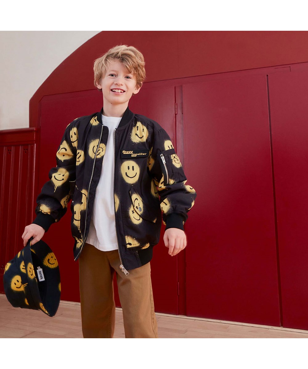 Heath - Happy! - Svart bomberjacka med gula smileys.