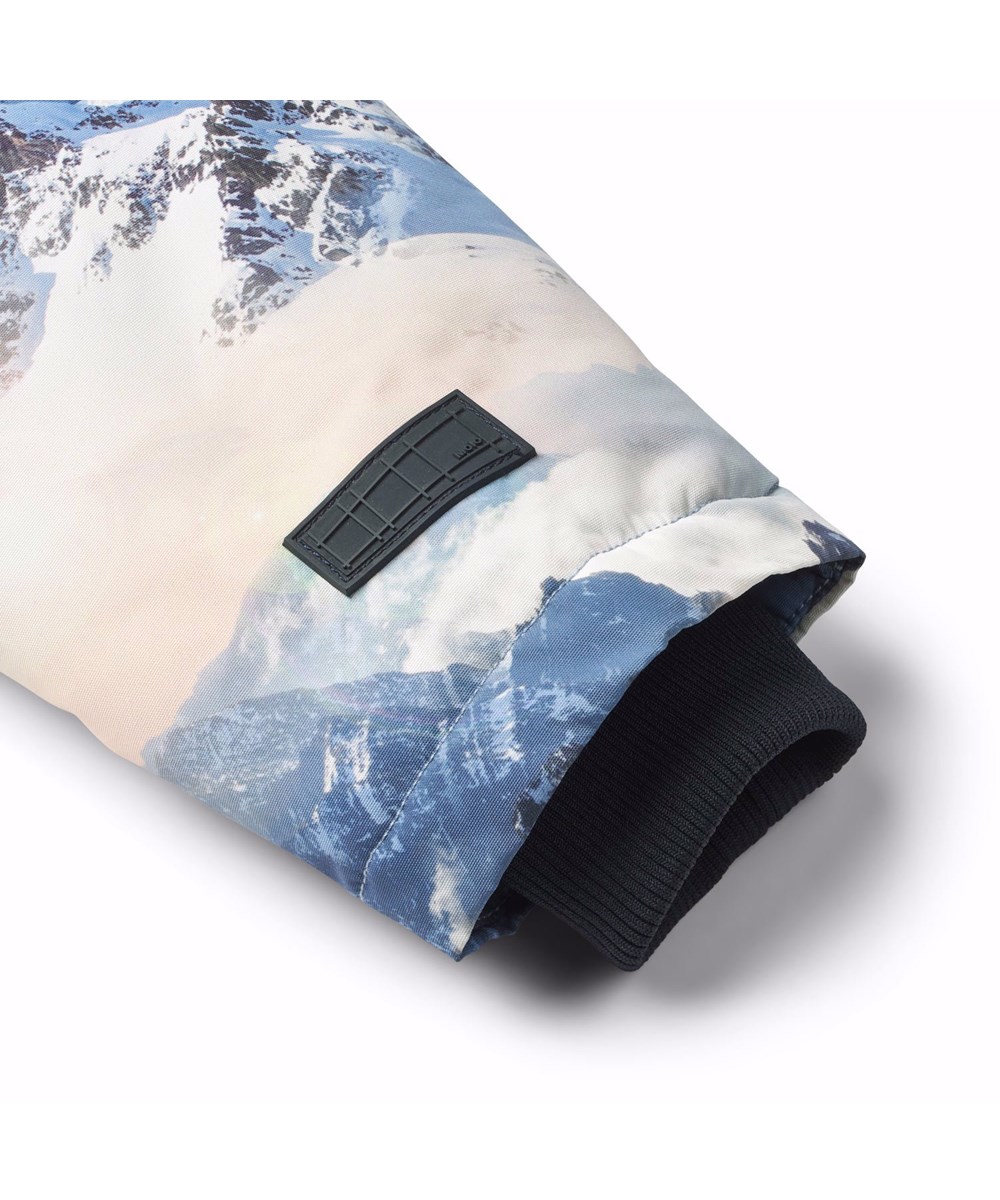 Heiko - Mountain High - Vind- och vattentät vinterjacka för barn i återvunnen polyester med ett tryck av ett vinterlandskap i nyanser av blått.