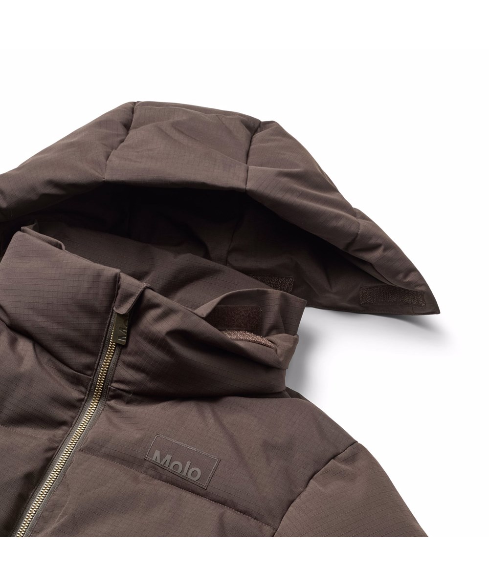 Hilo - Dark Cocoa - Varm och funktionell brun jacka för barn i återvunnen polyester med praktisk dragkedja, hög krage och avtagbar huva.