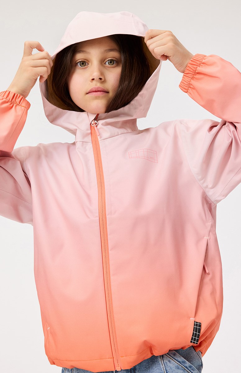 Horizon - Fade Pink - Vind- och vattentät jacka för barn i återvunnen polyester med en huva i rosa och orange gradientfärger.