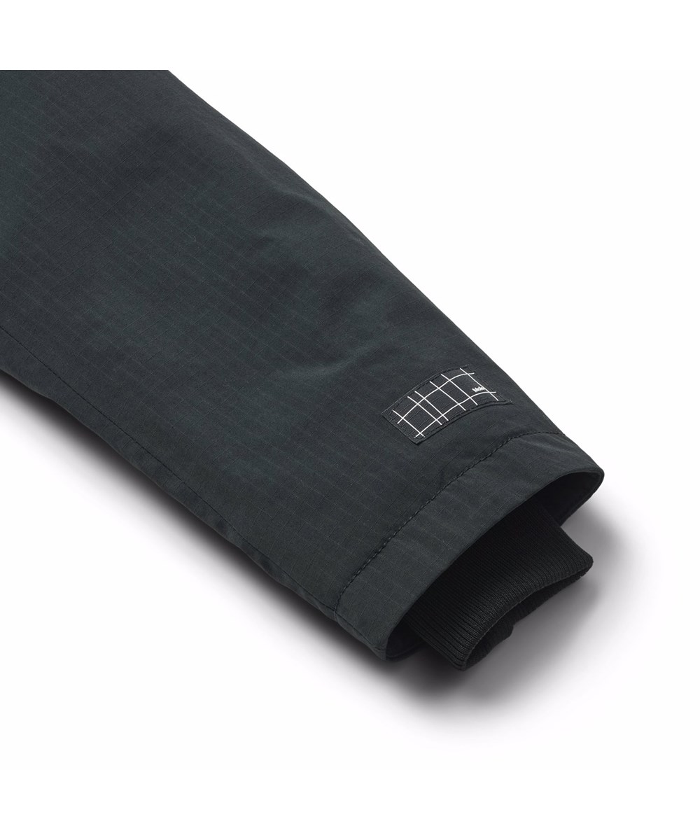 Peace - Black - Vind- och vattentät svart jacka i återvunnen nylon med praktisk dragkedja, hög krage och avtagbar huva med fuskpälskant.