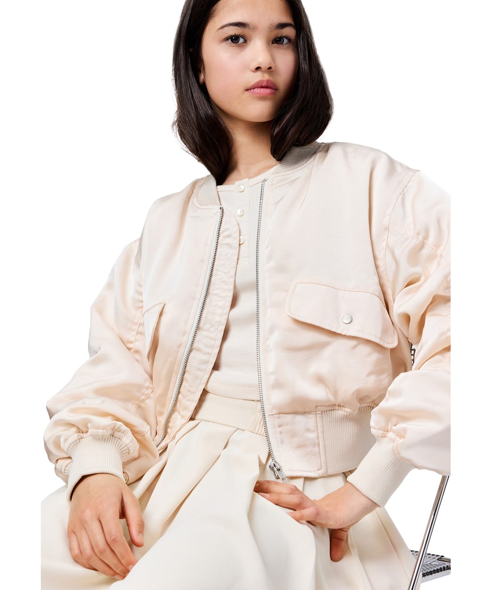 Hannie - Soft Powder - Off-white kort bomberjacka för barn med en lätt glans och vadderat foder.