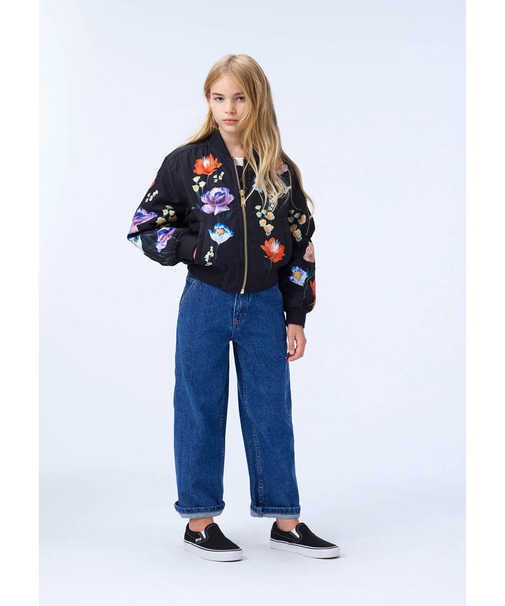Hedia - Paper Flora - Svart bomberjacka för barn med ett färgglatt blommönster tillverkad av återvunnen polyester.