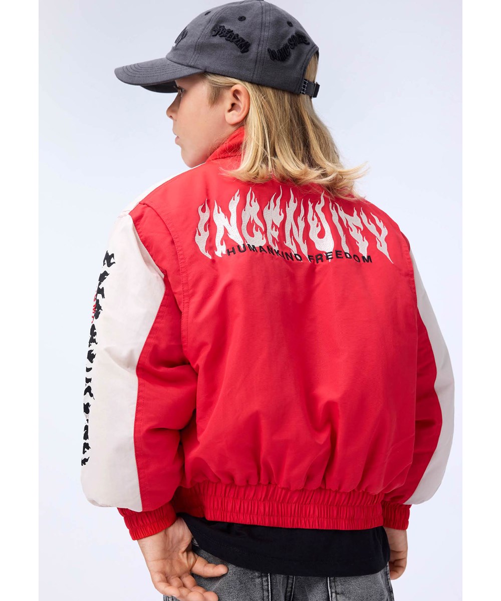 Herold - Vivid - Röd och vit jacka för barn med en broderad text på ryggen och ärmen,"Ingenuity humankind freedom".
