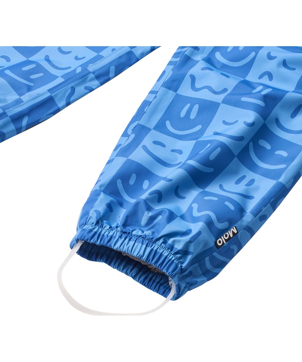Waits - Vibe Checks BLU - Vattentäta regnbyxor i återvunnen polyester. Byxorna är i blå nyanser med ett rutigt tryck av olika emojis.