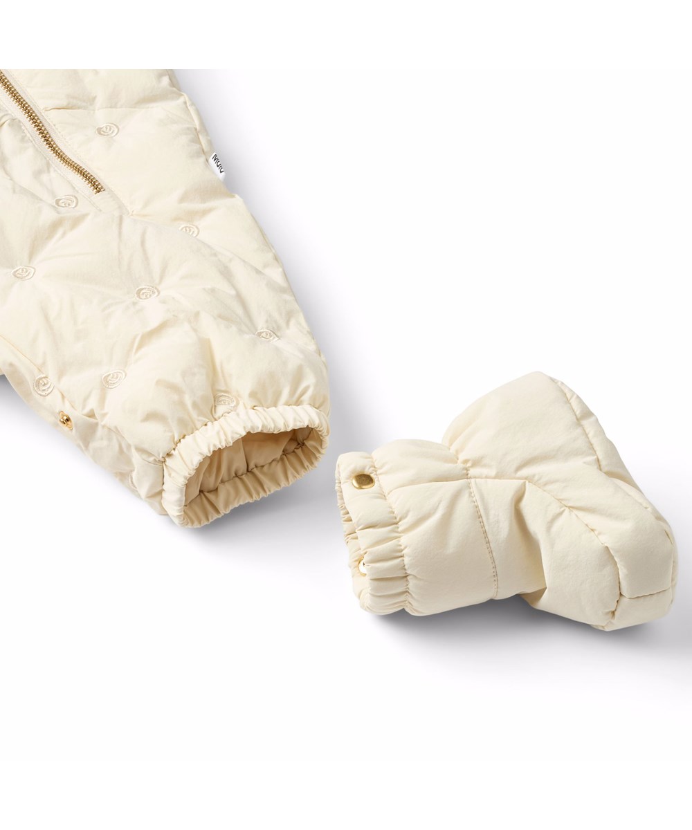 Hebe - White Noise - Vattenavvisande babyoverall i off-white med små broderade smileys tillverkade av återvunnen nylon.