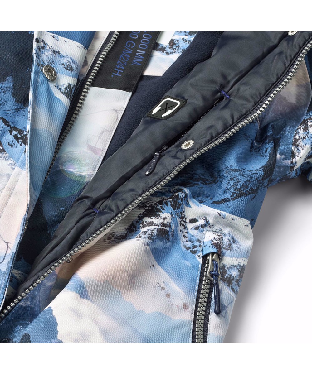 Hux - Mountain High - Barnoverall i återvunnen polyester, med ett vinterlandskap i blåa nyanser.