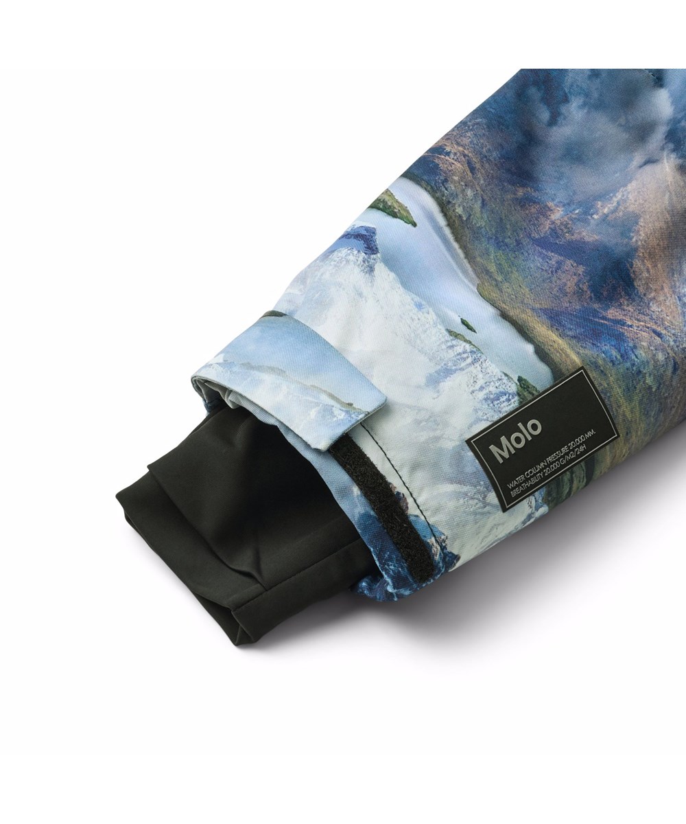 Hux - Snowy Mountains - Vind- och vattentät overall med ett vackert landskapsmönster som visar snötäckta bergstoppar i levande färger, tillverkad av återvunnen polyester och vadderad med 3M™ Thinsulate™.