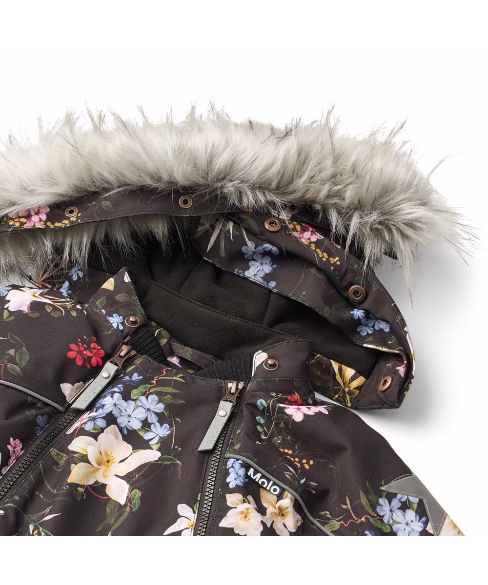 Pyxis Fur - Paisley Flowers - Svart vind- och vattentät overall för en kall vinter med ett färgglatt blommönster tillverkat av återvunnen polyester och vadderad med 3M™ Thinsulate™.